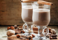 Hot cocoa with cinnamon, chocolate and nuts, selective focus